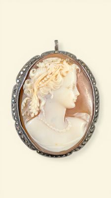 a close up of a picture of a woman ' s face in a pendant