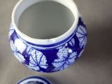 a blue and white vase sitting on a table next to a blue and white plate