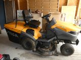 une tondeuse à gazon jaune et noire garée dans un garage