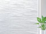 a white vase with a plant sitting on a table next to a window
