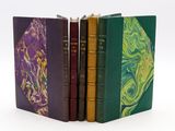 trois livres sont empilés sur une surface blanche