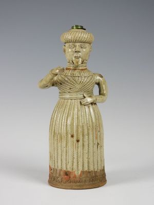 figurine représentant une femme coiffée d'un chapeau