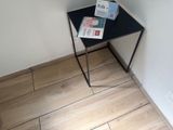 une petite table noire sur laquelle est posé un magazine