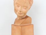 an image of a clay sculpture of a child ' s head on a block