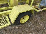 a yellow trailer with a yellow wheel on the grass