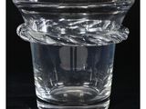 un vase en verre entouré d'une corde, posé sur une surface noire