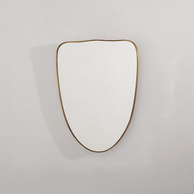 un miroir plaqué or accroché à un mur blanc
