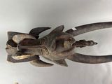 a wooden sculpture of a fish on a white surface