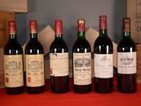 several bottles of wine are lined up on a red table
