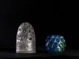 three different colored glass vases sitting on top of a black surface