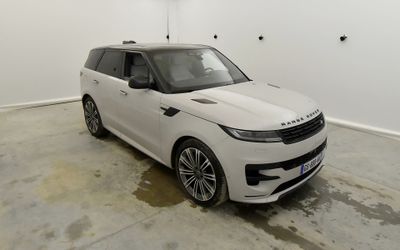 Le Range Rover blanc est garé dans une grande pièce.