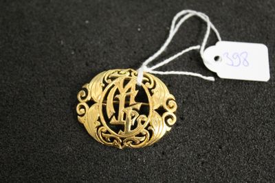 un gros plan d'un collier en or orné d'un monogramme