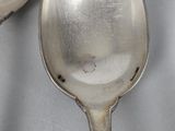 two spoons that are sitting next to each other on a table