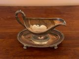 a silver gravy sitting on top of a wooden table