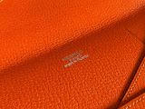an orange leather wallet with a card holder on top of it