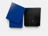 a black and blue book with a blue cover next to it