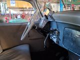 dashboard of an old car in a garage with a lot of signs on the wall