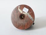 a red and white marble object with a tag on it