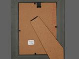 an old picture frame with a piece of paper sticking out of it