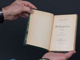 un homme tenant un livre ouvert à la main