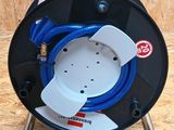 un gros plan d'un dévidoir auquel est raccordé un tuyau bleu