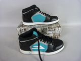 black and teal high top sneakers with blue accents on top of a box