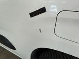 a close up of a white car with a sticker on it