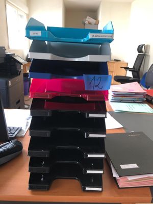 a stack of folders sitting on a desk next to a computer