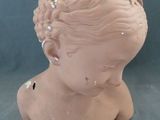 une tête d'enfant en argile sur fond bleu
