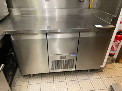 a stainless steel kitchen with a sink and a refrigerator