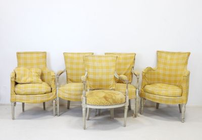 four chairs and a table in a room with a wall in the background