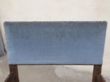 a blue upholstered chair with a wooden frame