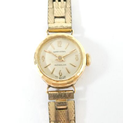 a gold wrist watch with a white dial on it