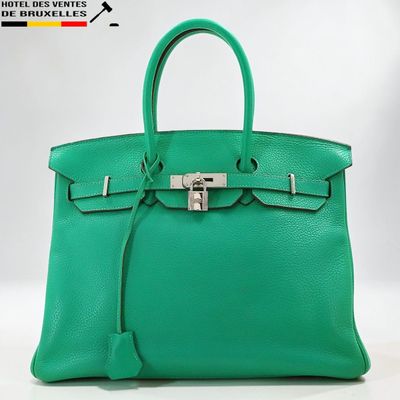 un sac à main en cuir vert muni d'un cadenas sur la poignée