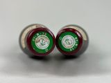 pair of red and green wine bottles sitting on a white surface