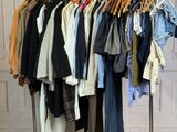 a lot of clothes hanging on a rack in a room