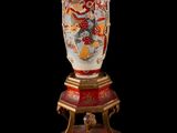 a vase that is sitting on a stand on a black background