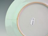 a white plate with a green rim and a brown rim