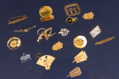 de nombreuses épingles et broches sur un fond bleu
