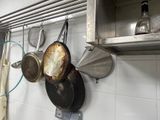 pots and pans hanging on the wall in the kitchen