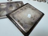 two silver trays sitting on a table next to each other