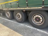 a large green truck that is parked on the side of the road