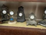 de nombreuses horloges différentes posées sur une étagère dans un meuble