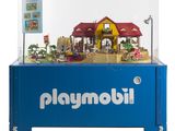 une vitrine Playmobil contenant une maison de poupées