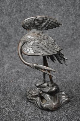 un gros plan sur la statue d'un oiseau posé sur un rocher