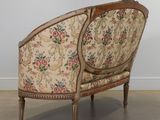 an old chair with a floral upholstered back and wooden legs