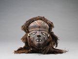 une image représentant un masque en bois avec un grand visage et de longs cheveux