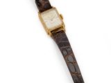 un gros plan d'une montre sur une surface blanche avec un fond blanc