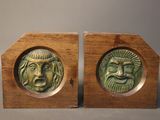 pair of wooden bookends with faces on them on a table