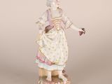une figurine ancienne représentant une femme tenant une fleur à la main